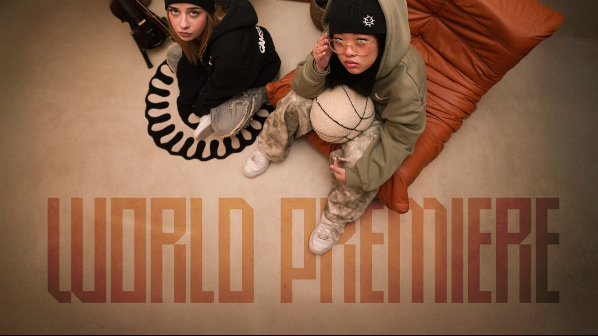 Two girls sitting on a couch with 'World Premiere' text overlay.